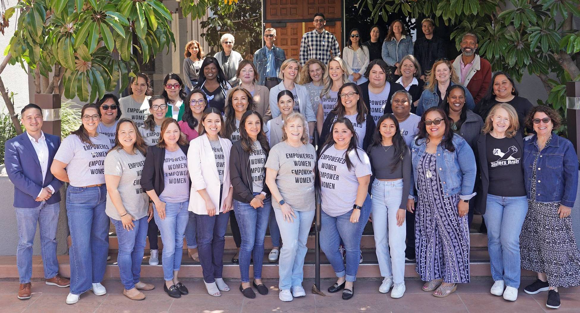 About forty people take a group photo to show their jeans on denim day to support abused women