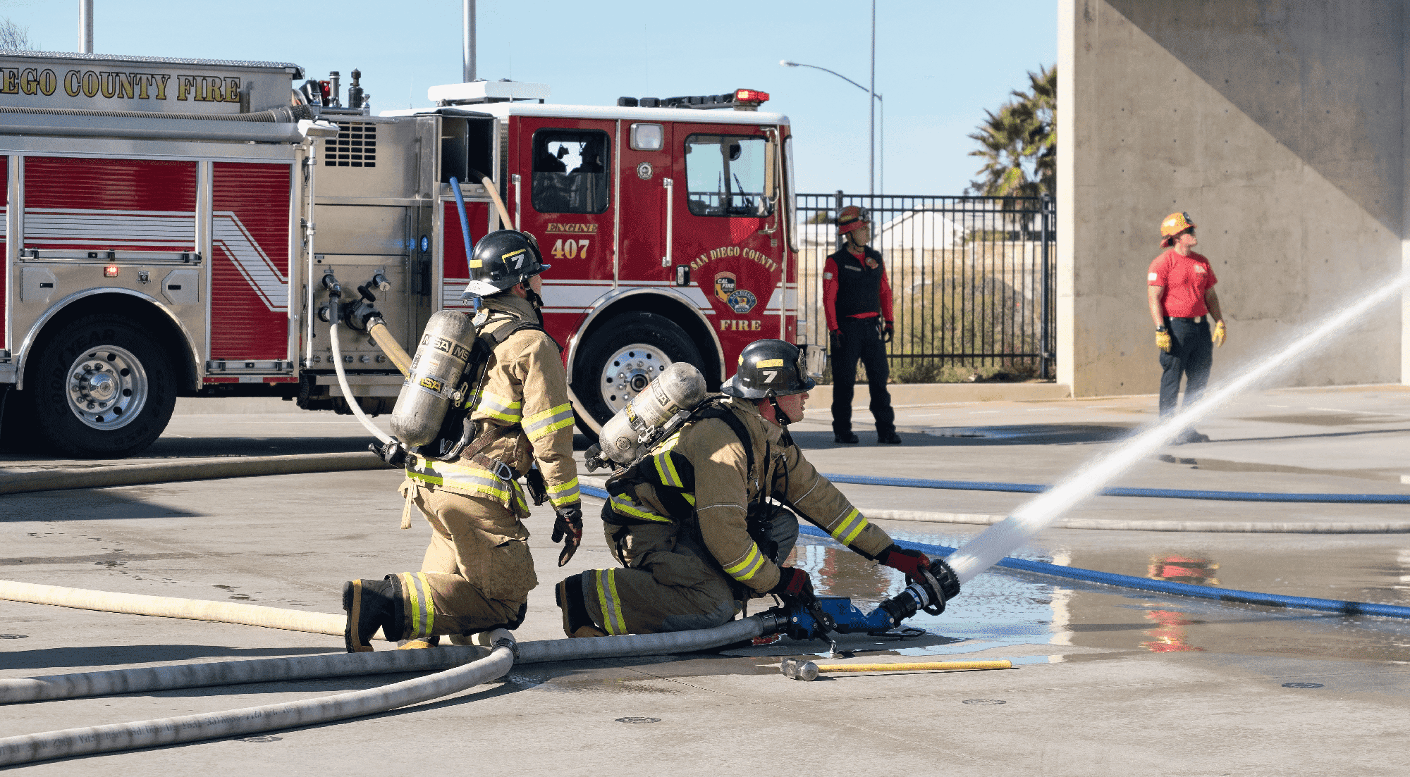 Students in the fire academy direct a fire hose at a fire