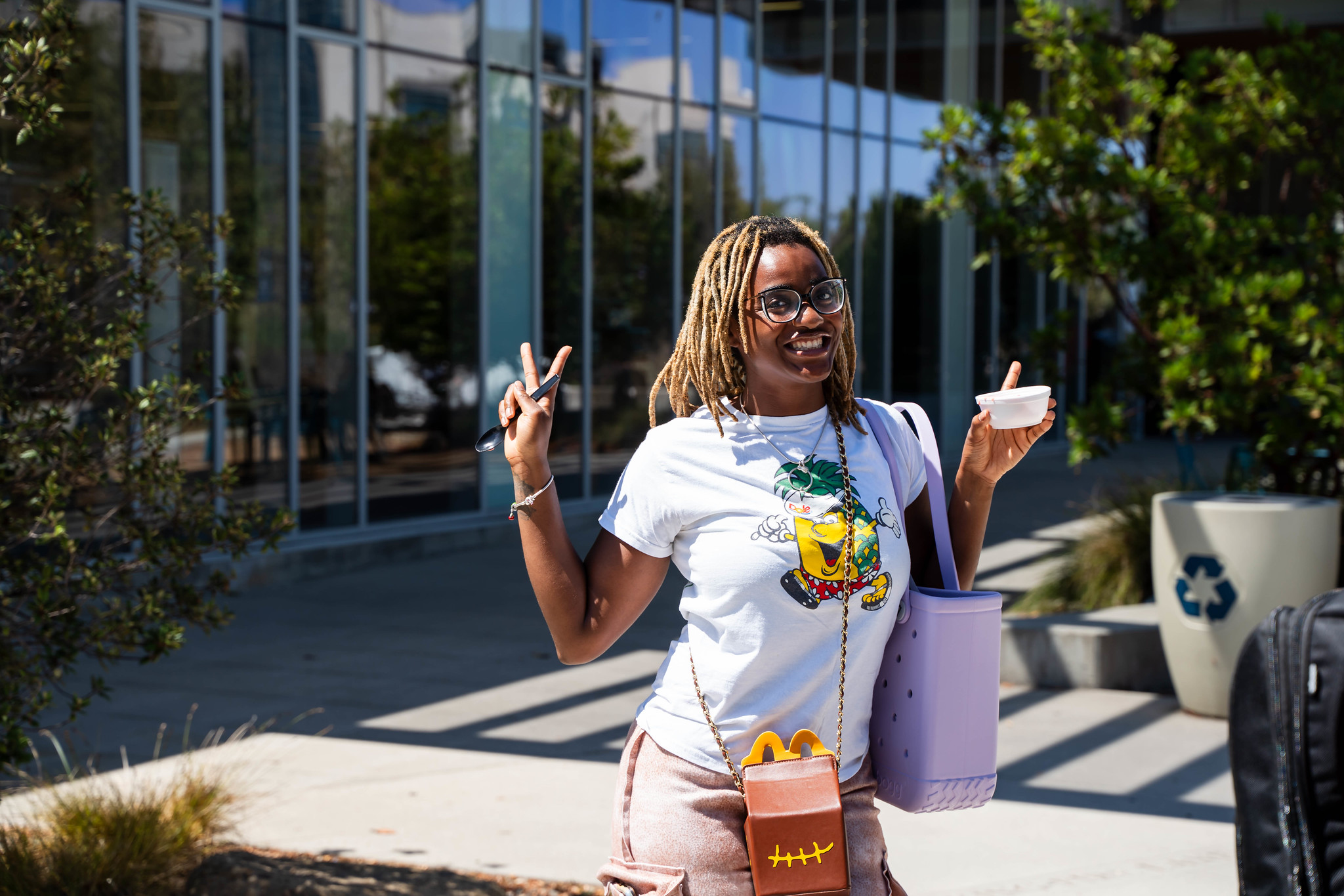 A student gives a peace sign while eating ice cream at Welcome Week