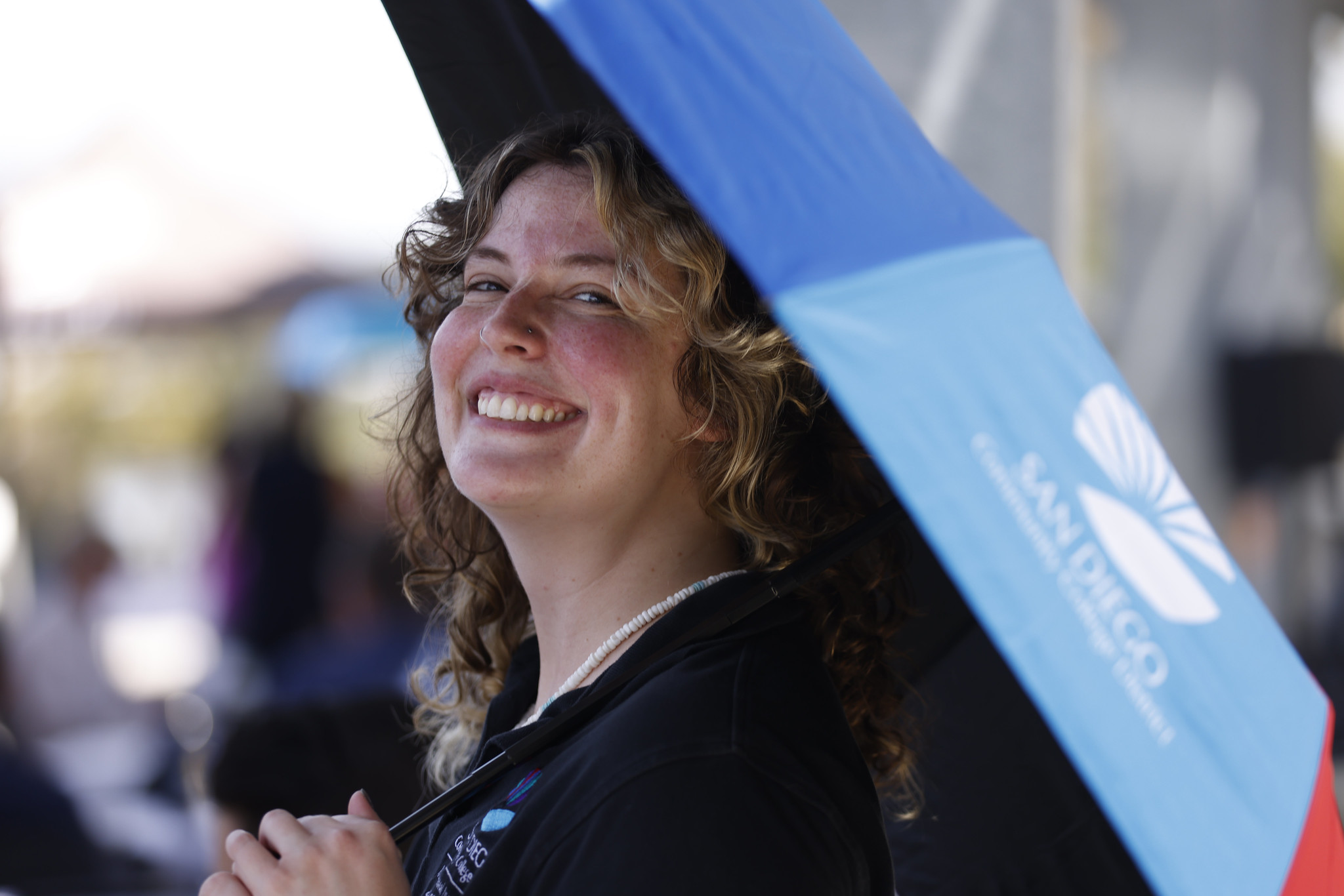 An employee smiling and hold a district umbrella
