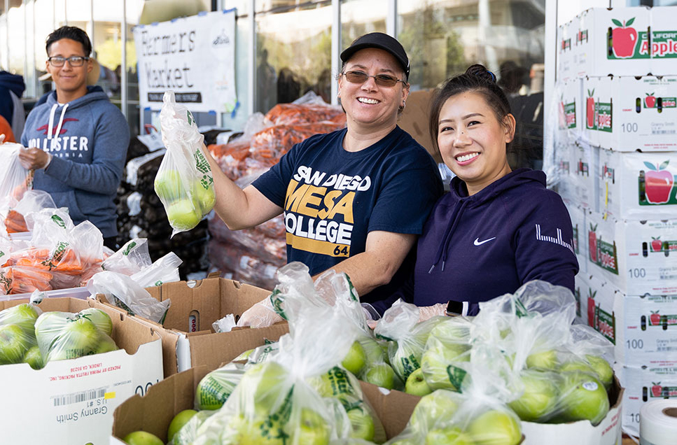 Two employees work the farmers market at Mesa College