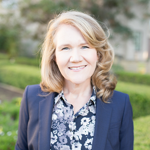 Poppy Fitch in a blue blazer and blouse, outdoors with trees and grass;