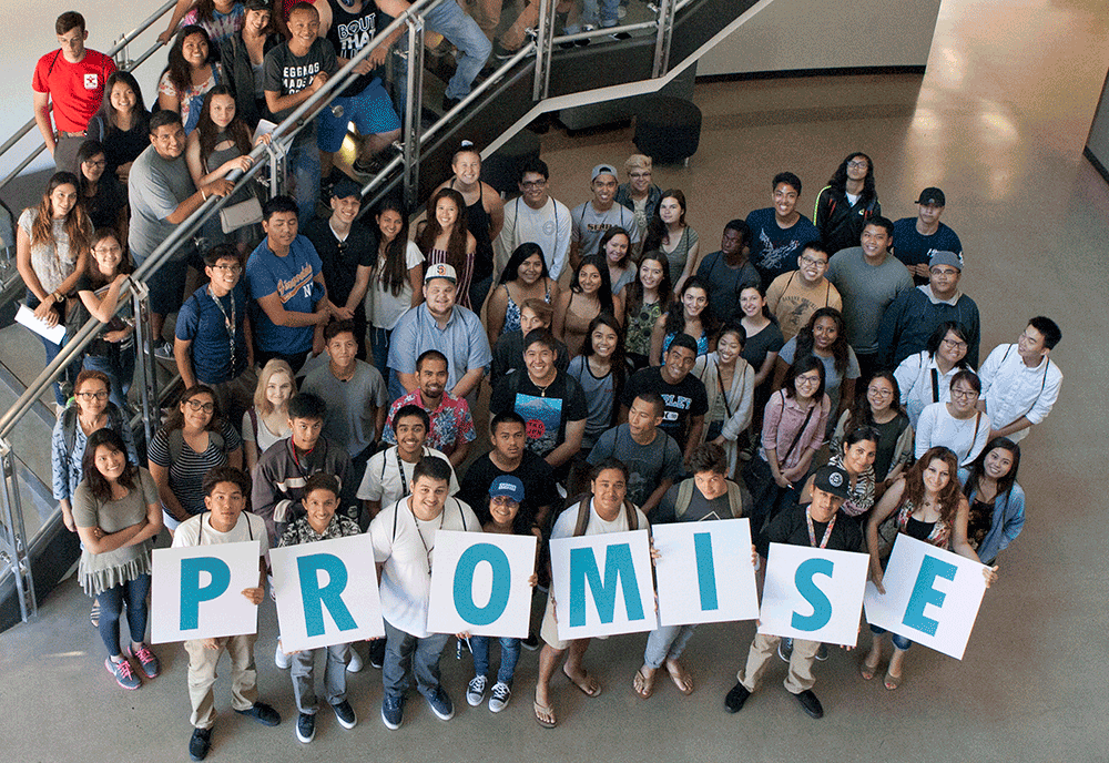 A group of students hold up letters spelling promise