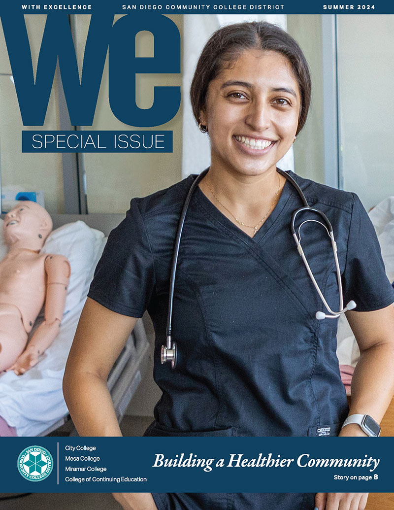 A student in blue scrubs and stethoscope is on the cover of the special health issue of WE Magazine