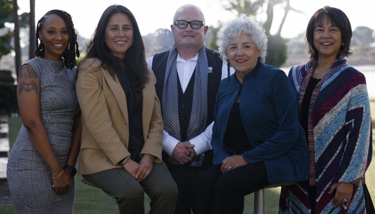 All five trustees outside by grass and trees