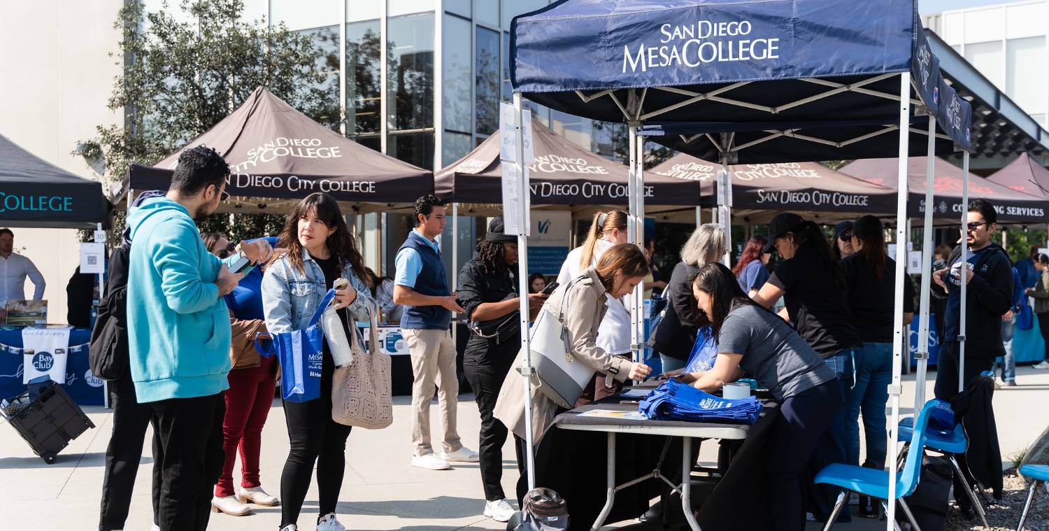 Booths set up for a career fair. Students are visiting the booths
