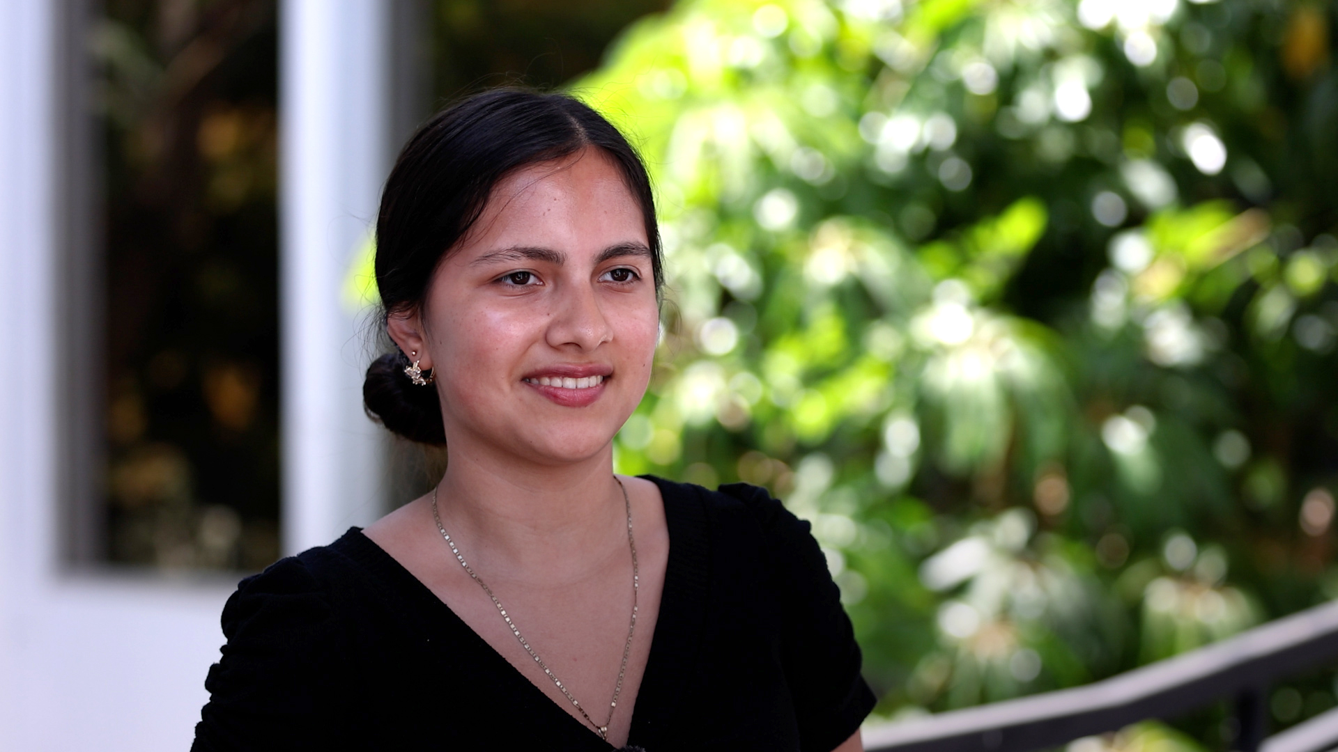 Celina Sanchez outside with greenery behind her