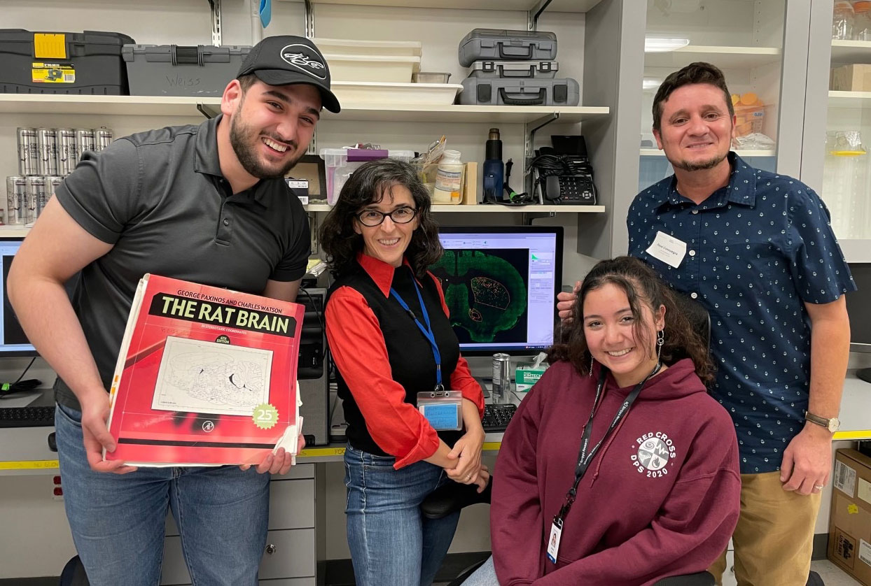 Four interns in front of a desk.