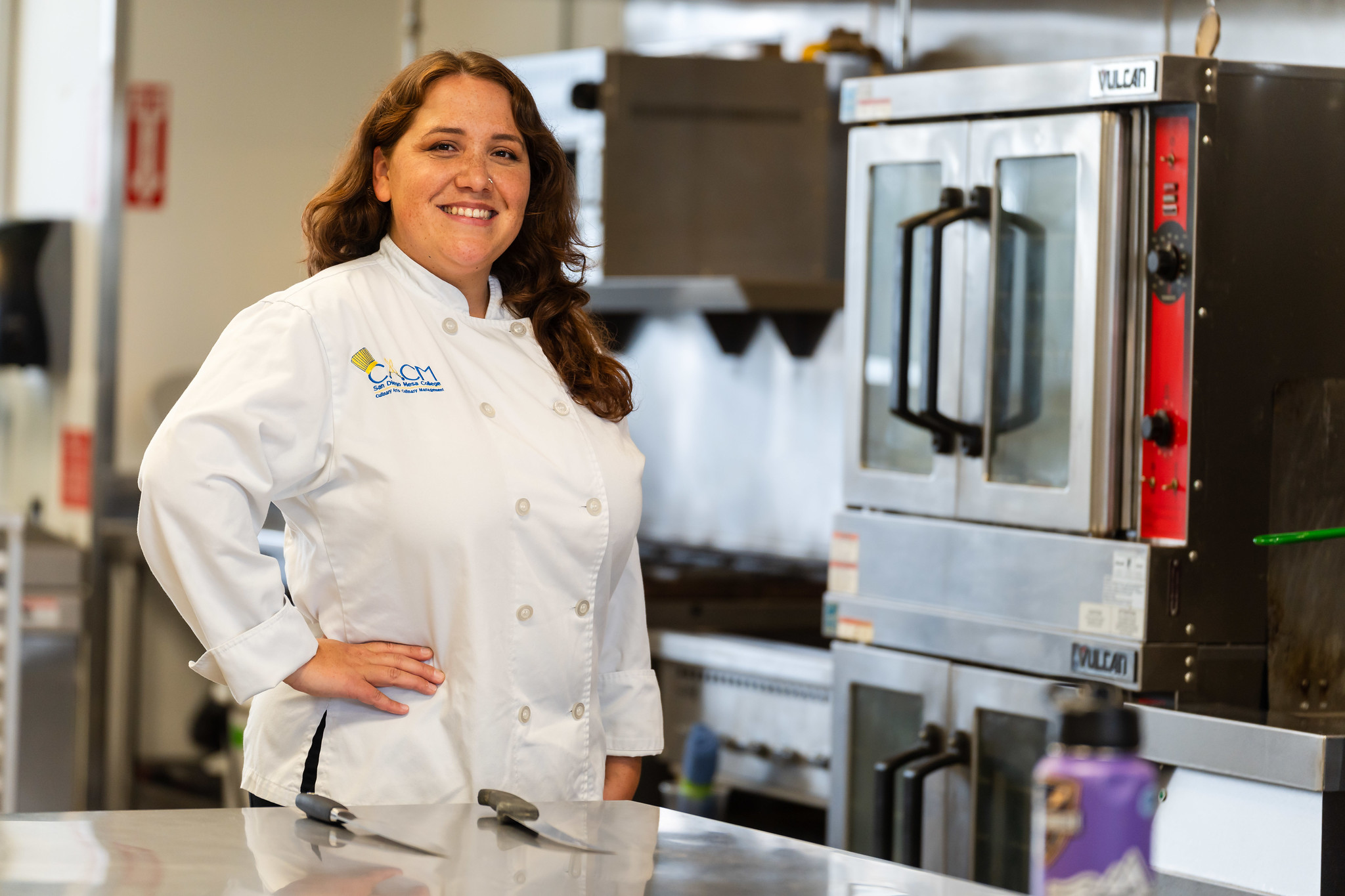 Melissa Chavez in a kitchen wearing a white chef's smock