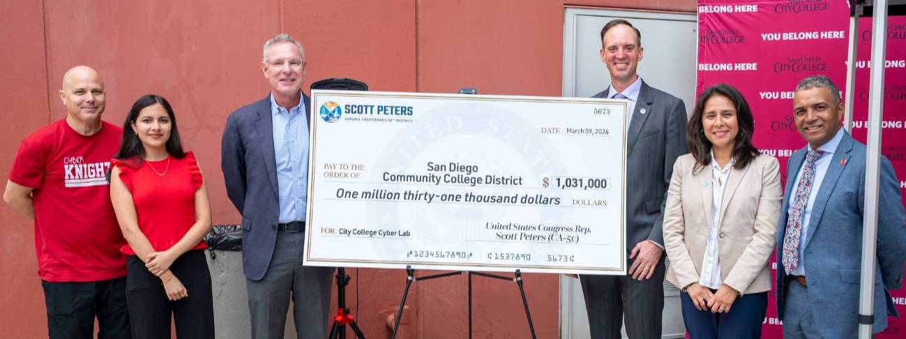 Six people stand next to a giant check for 1 million dollars.
