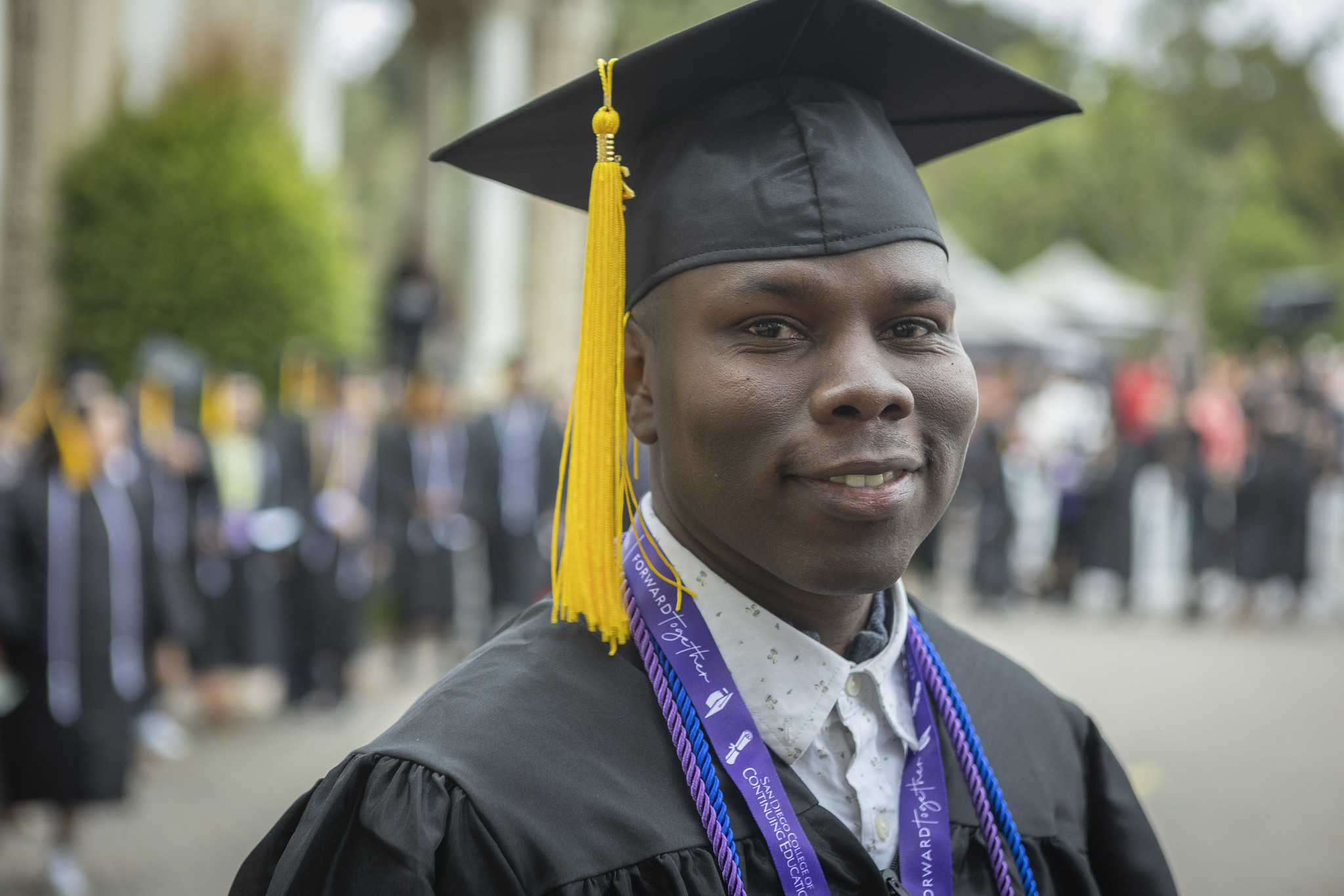 
A graduate smiling while in line to receive his certificate.
