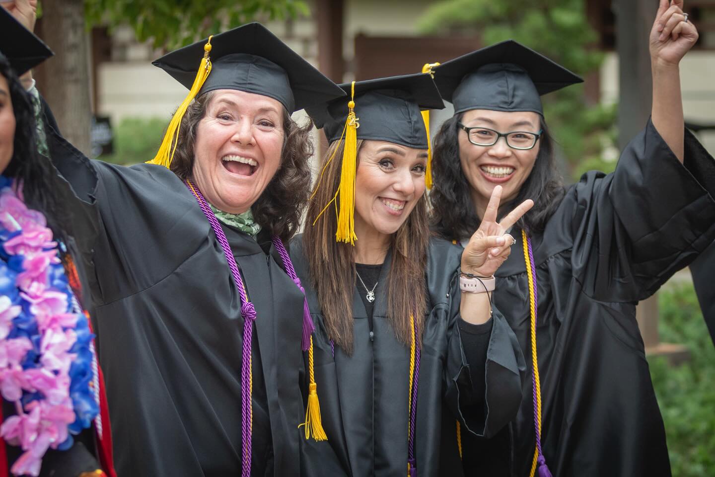 
Three graduates cheering at commencement.

