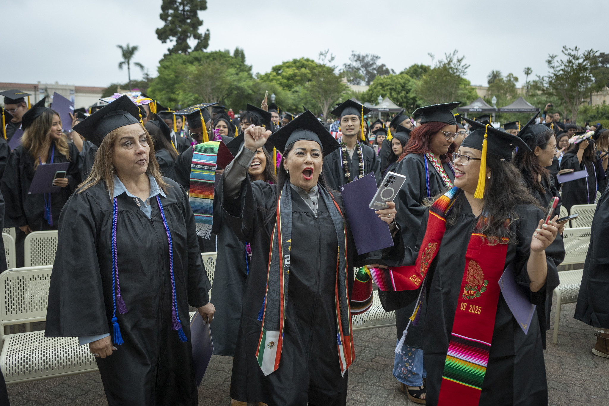 
Graduates in the audience cheering.

