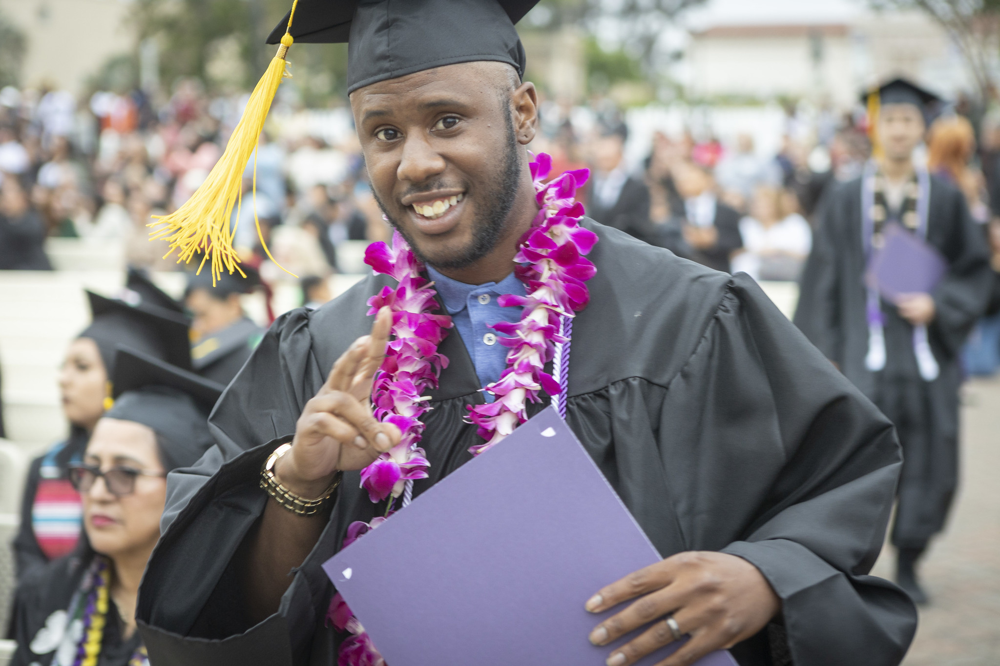
A graduate gives a peace sign after receiving his certificate.
