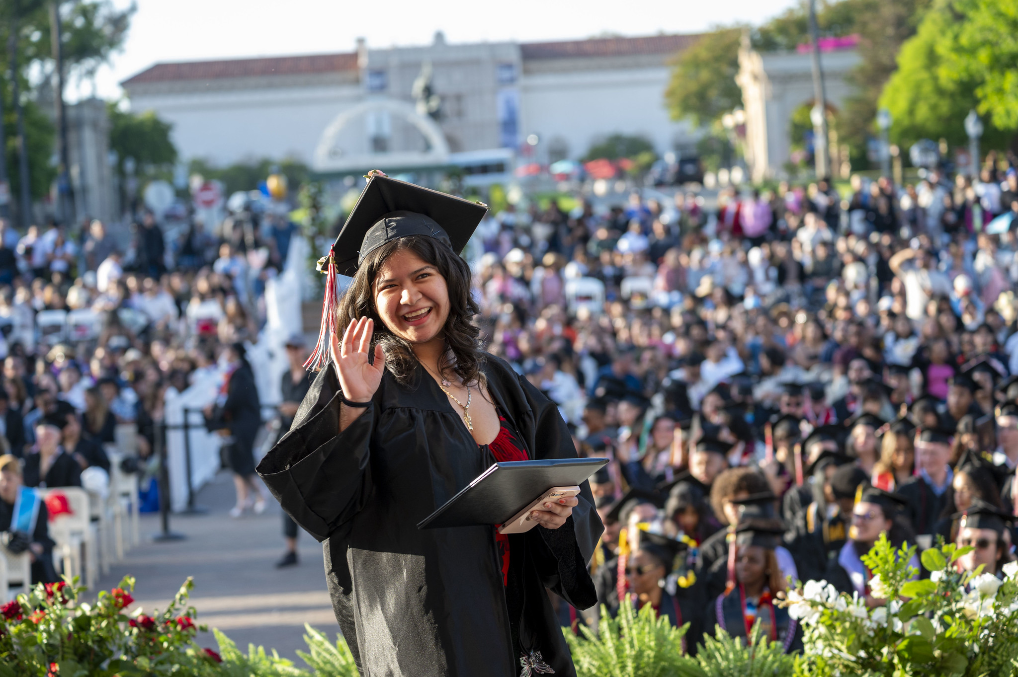 
A graduate waves as she walks across the stage.
