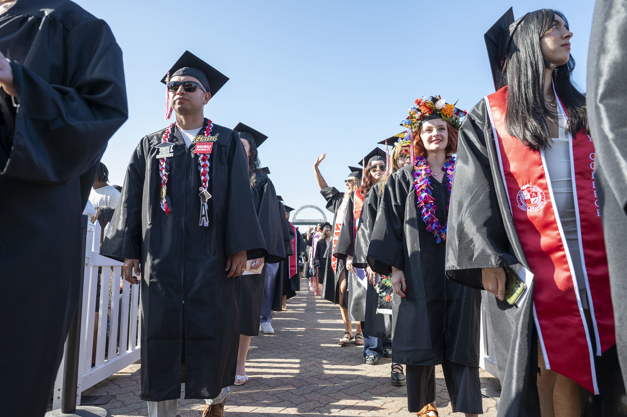 
Two lines of graduates head to their seats at commencement.
