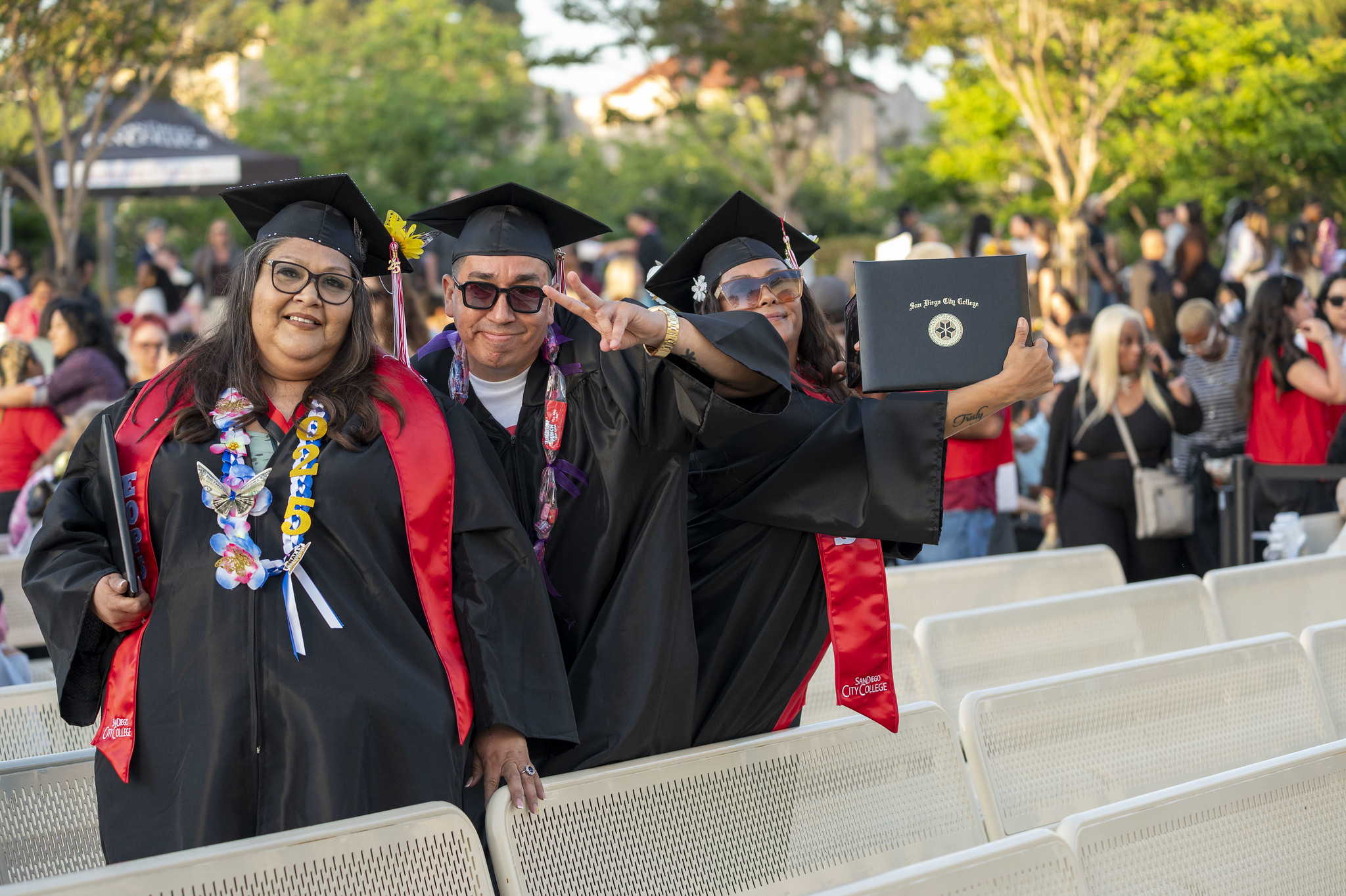 
Three graduates in the audience after receiving their degrees
