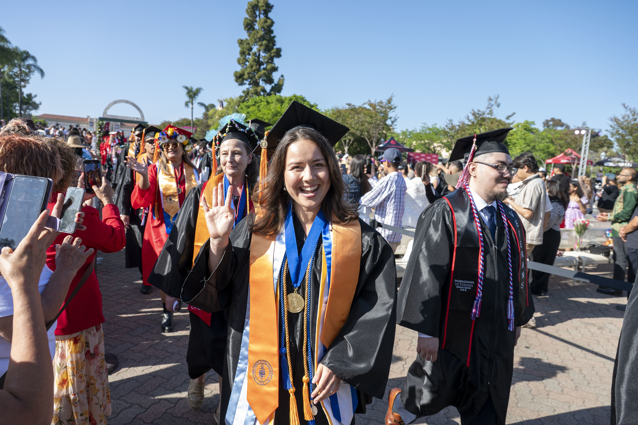 
A graduate waving in the crowd.
