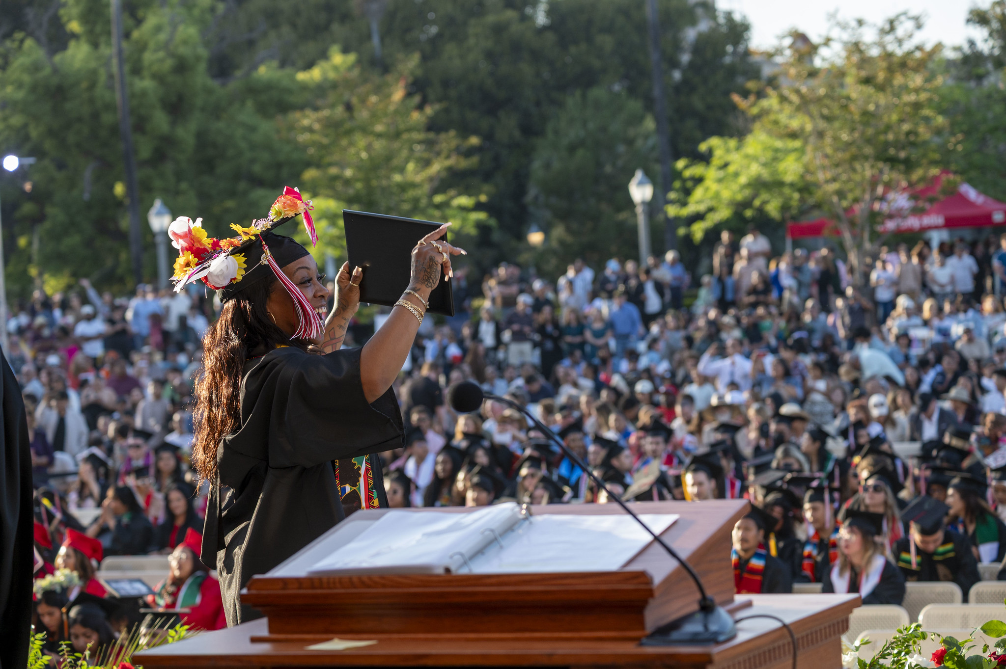 
A student shows the audience her degree as she walks across the stage.
