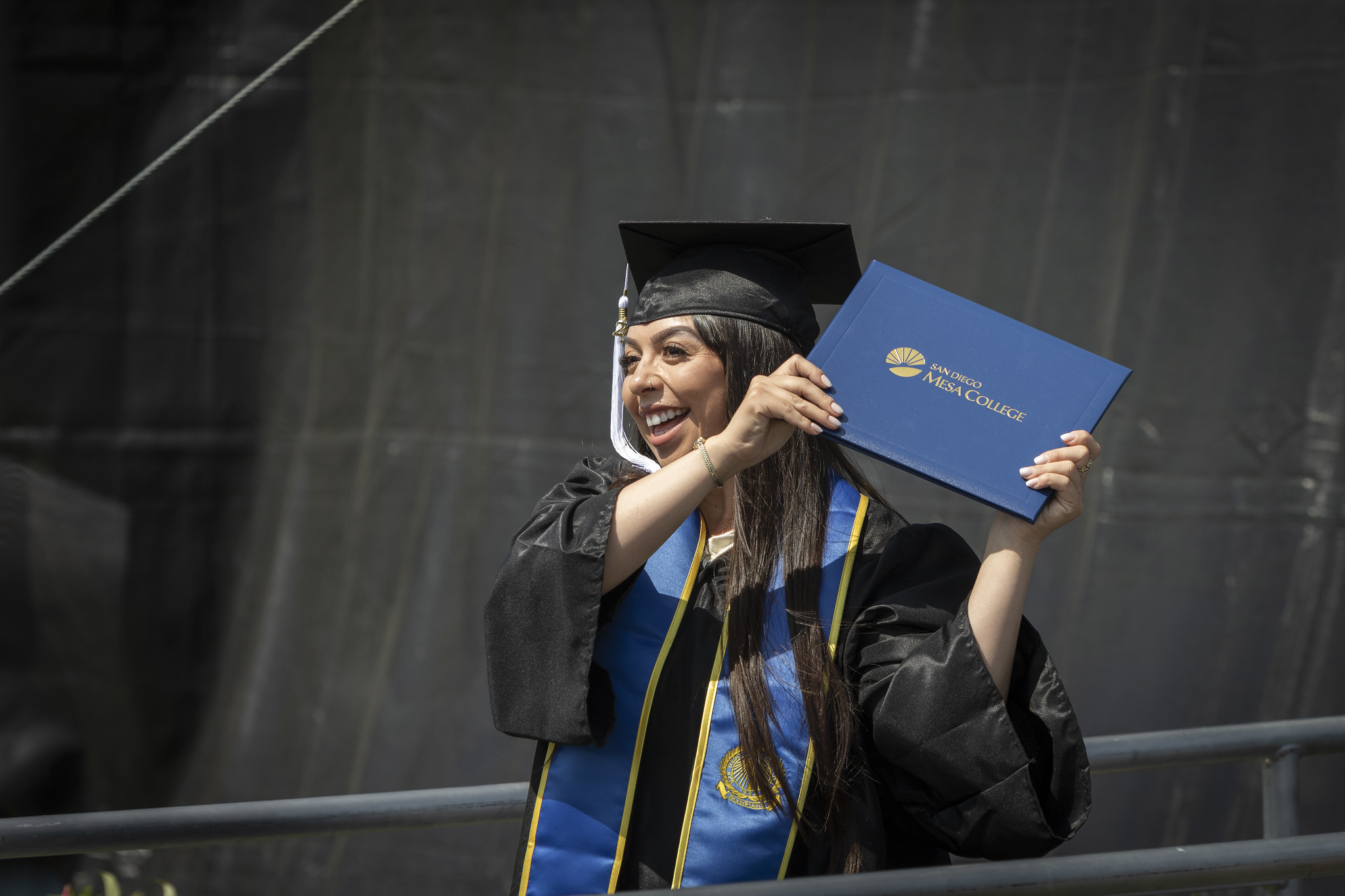
A graduated holds up her degree.
