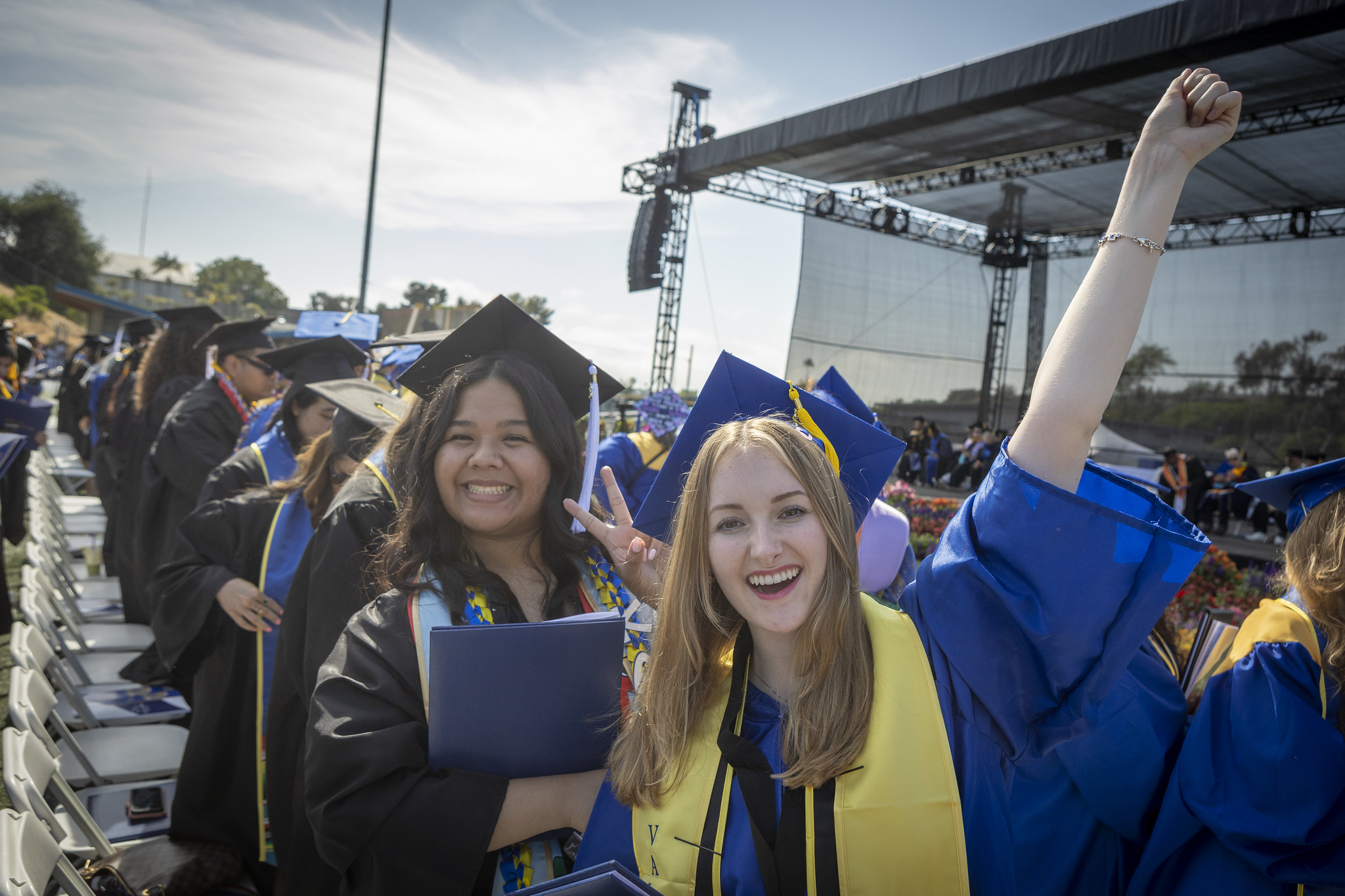 
Two graduates in the audience cheer after receiving their degrees.

