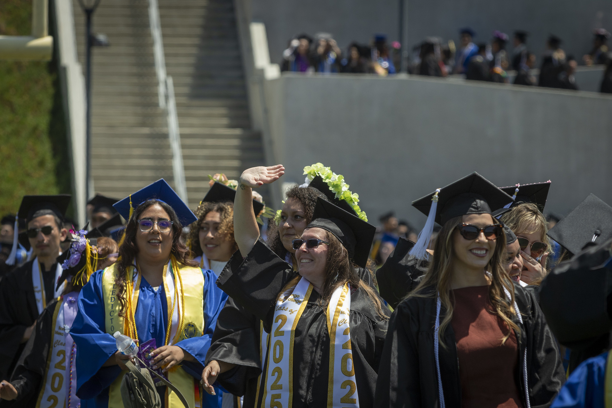 
A student waves to the crowd as she heads to her seat.
