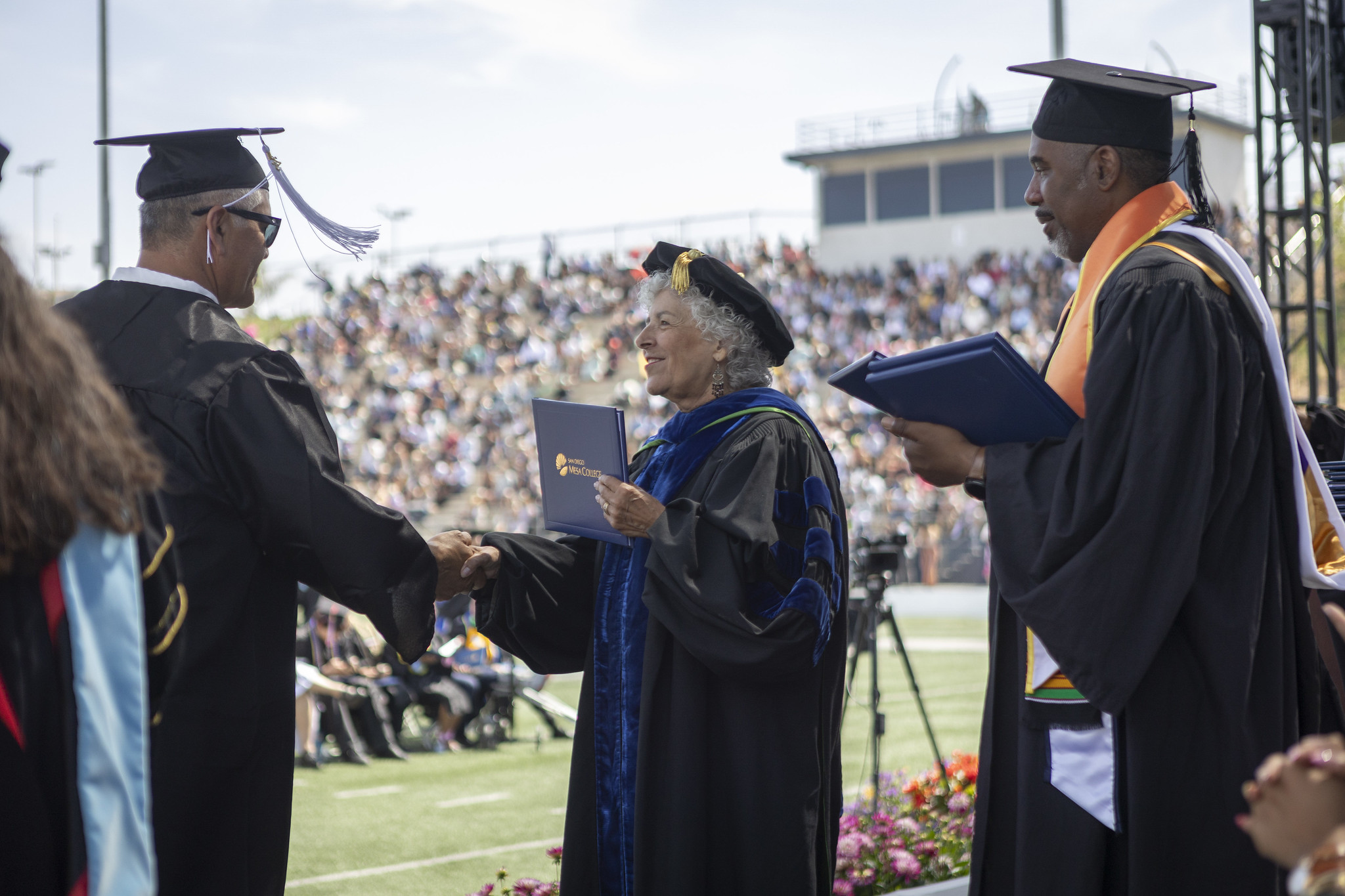 
Trustee Maria Nieto Senour shakes a graduates hand and give him a diploma.
