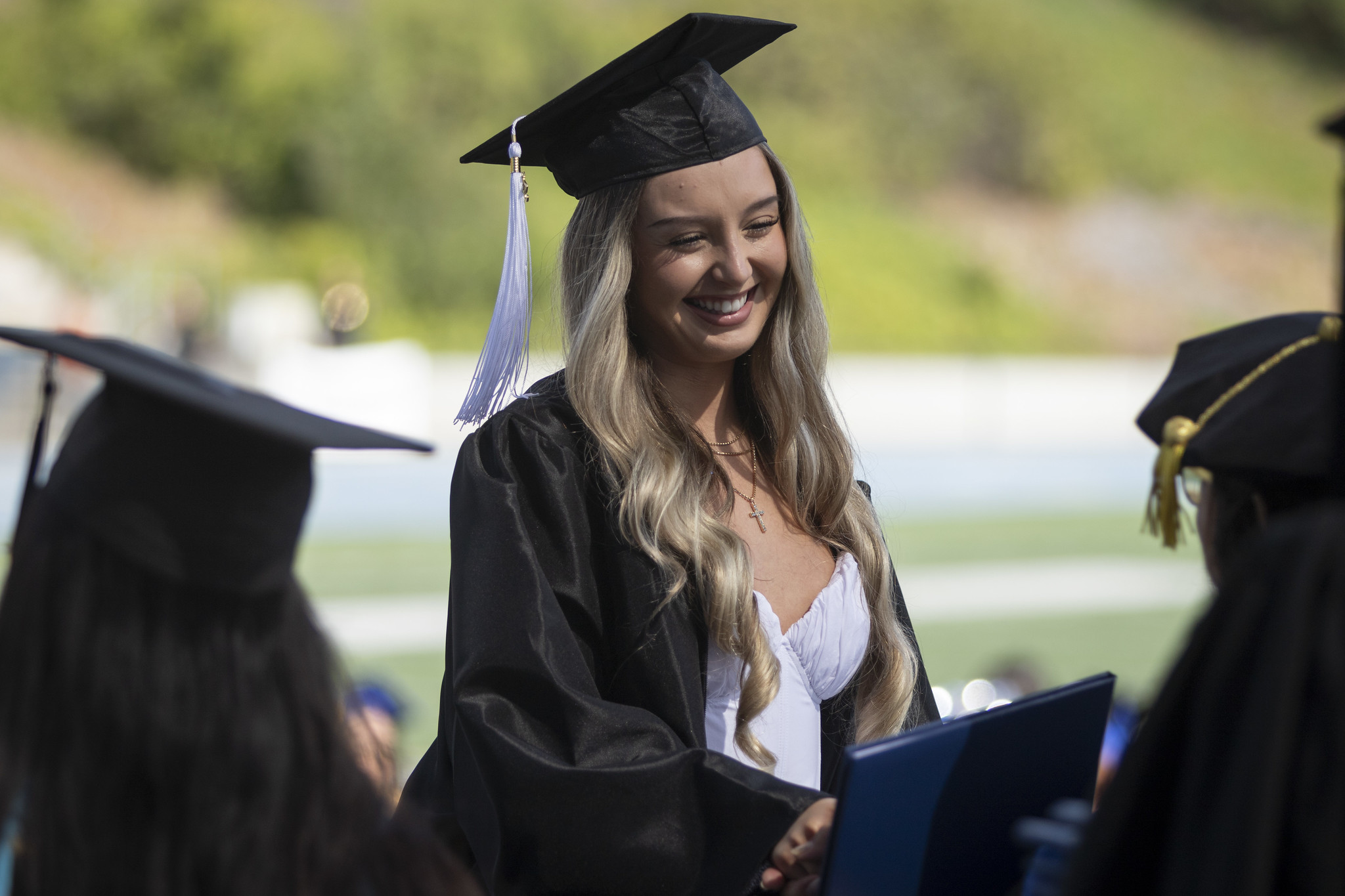 
A graduate smiling with her diploma.
