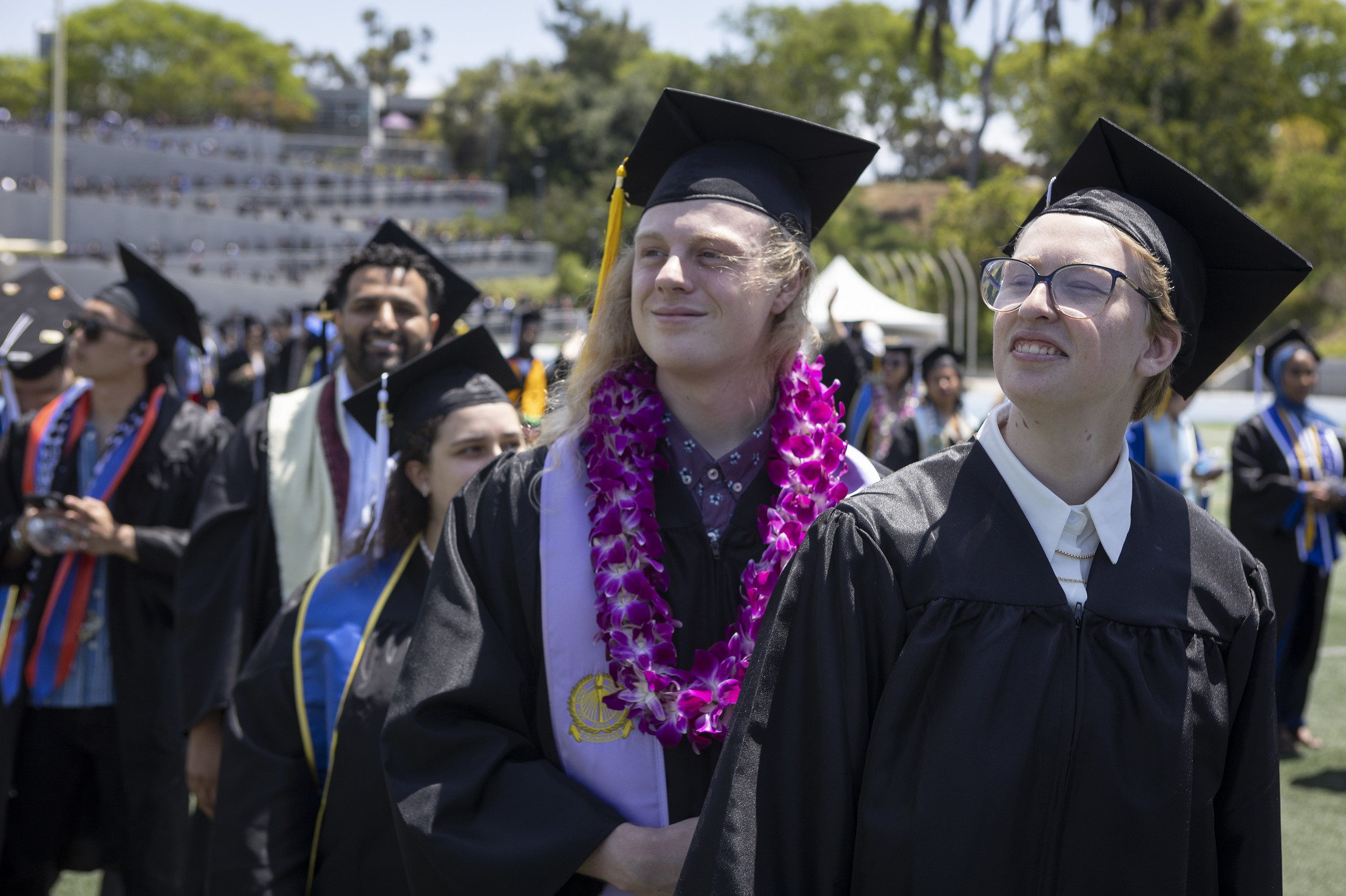 
Two graduates look toward the audience.
