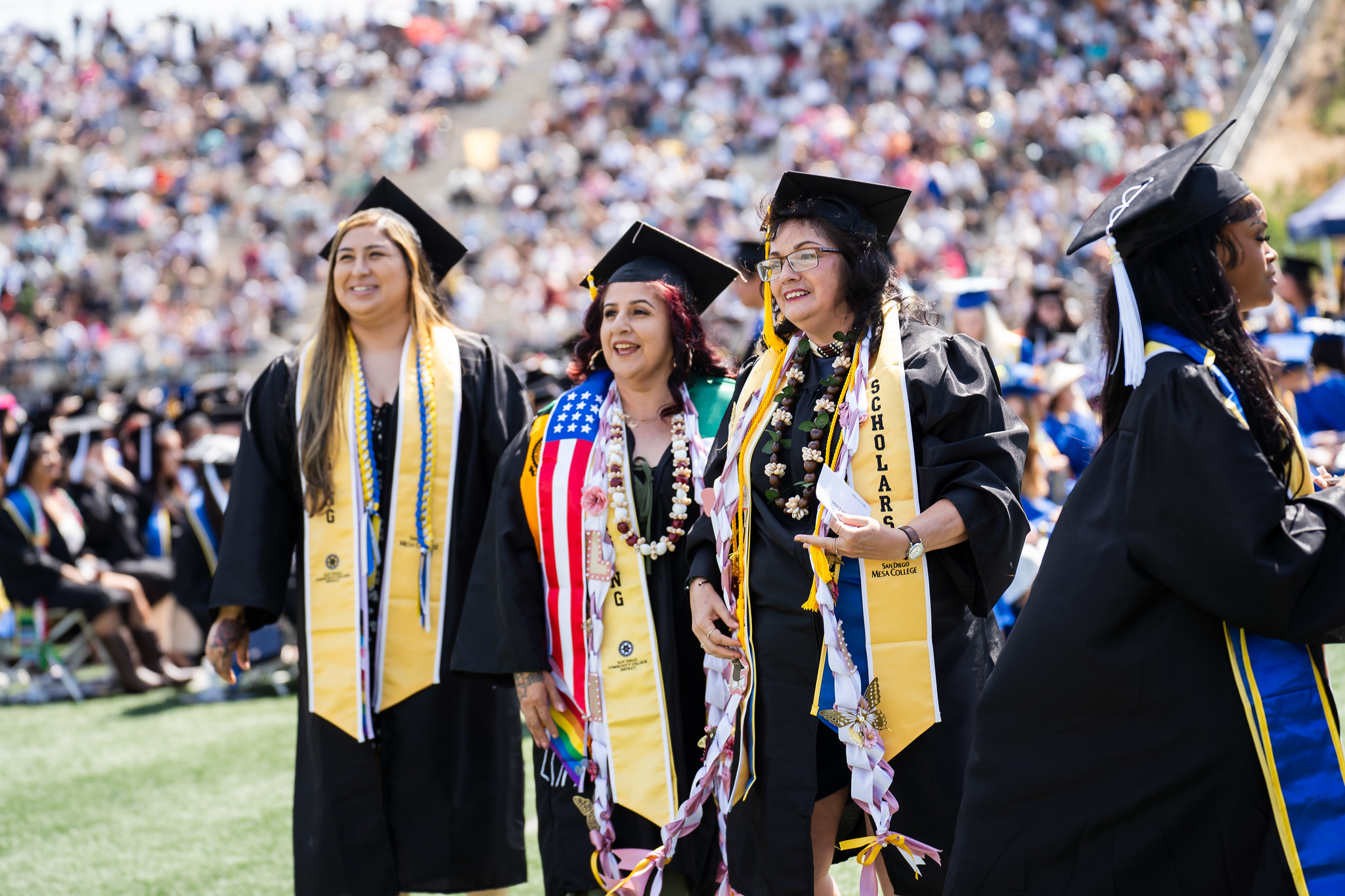 
Three graduates on the field at commencement.
