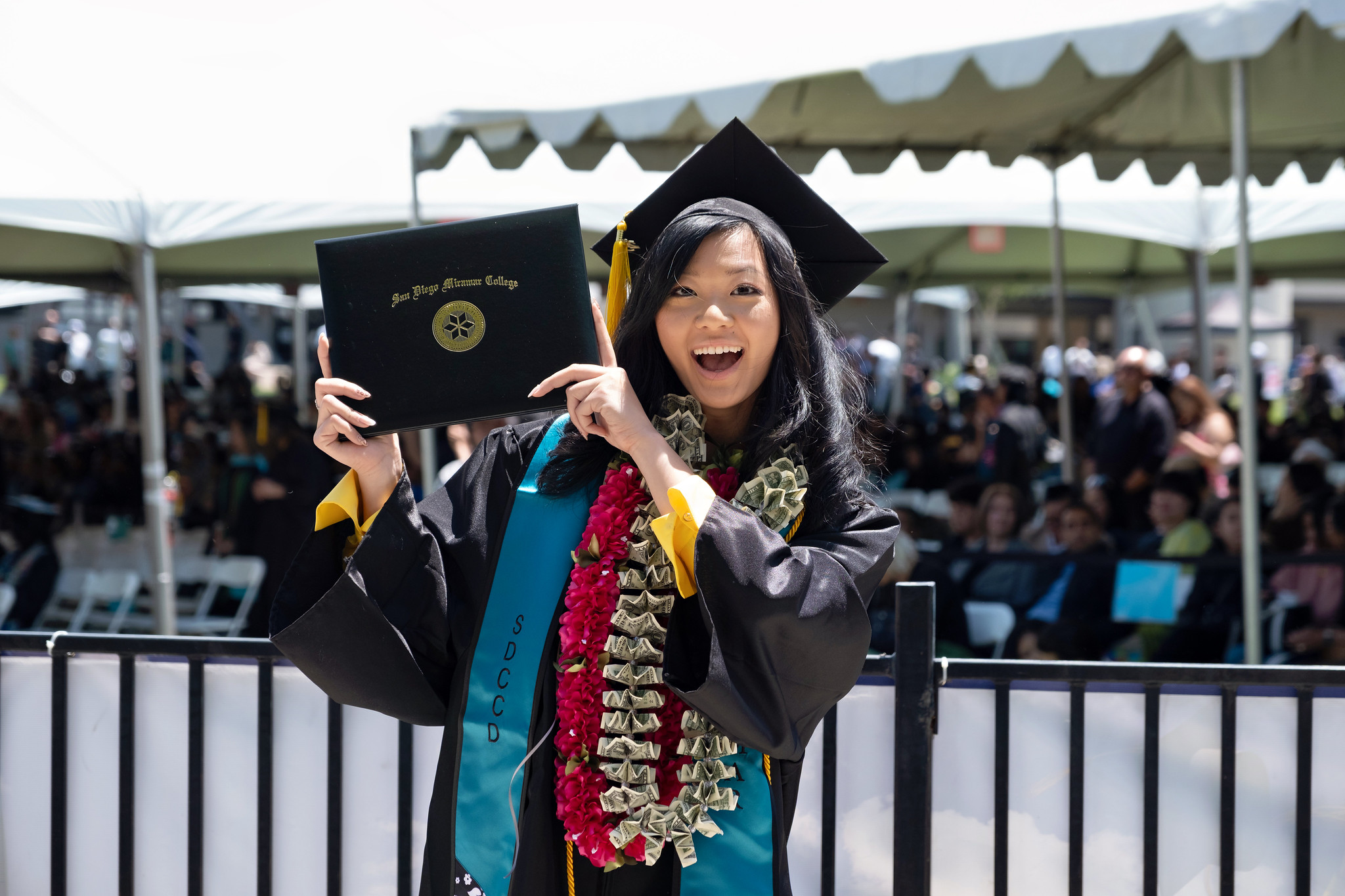 
A graduate is holding up her degree.
