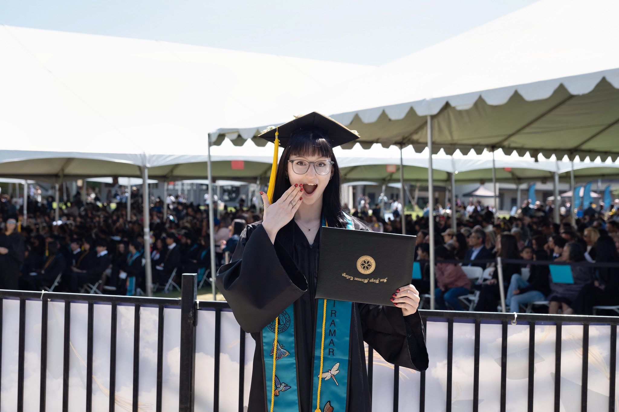 
A graduate is holding up her degree.
