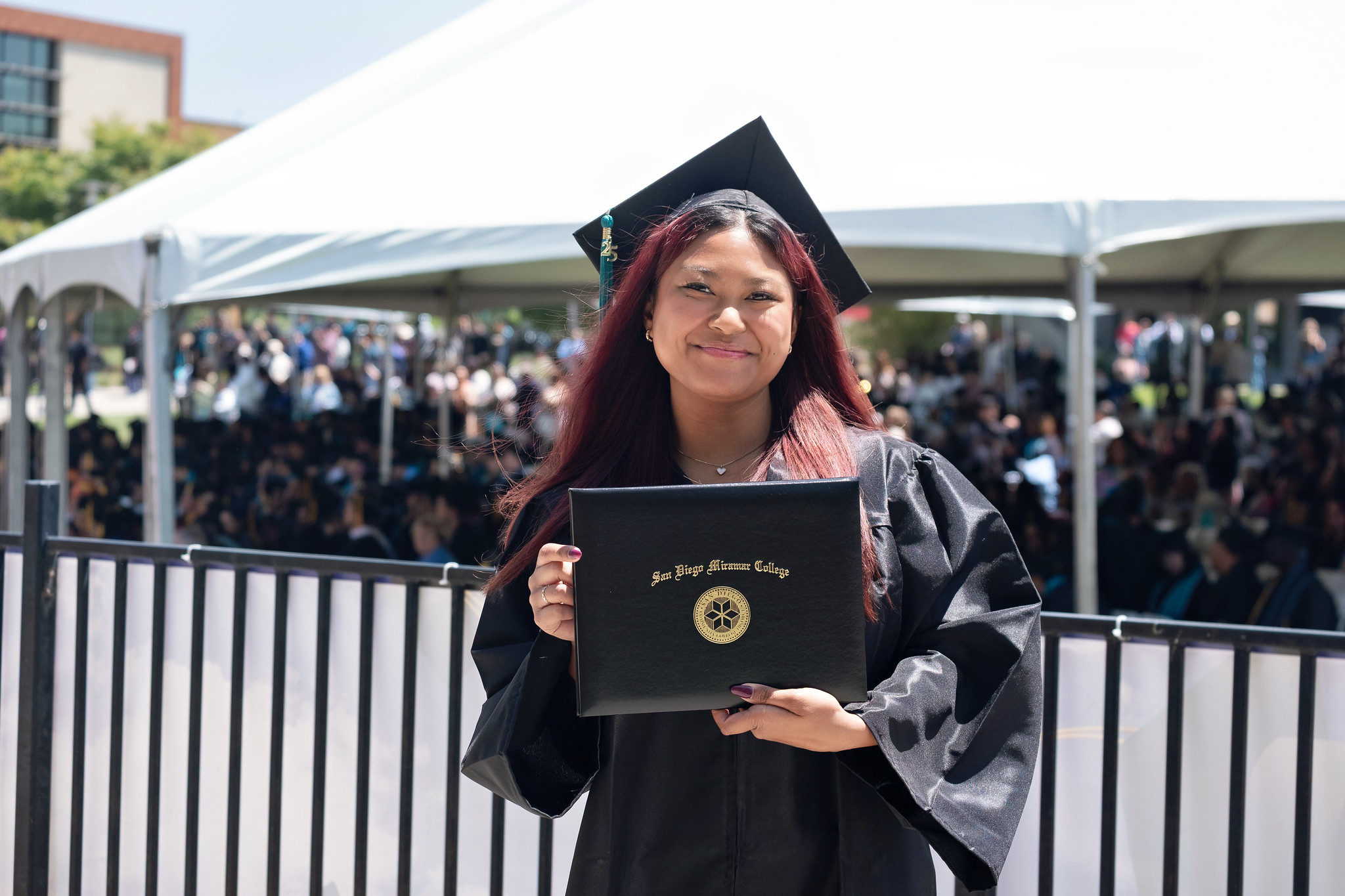 
A graduate holds up her degree.
