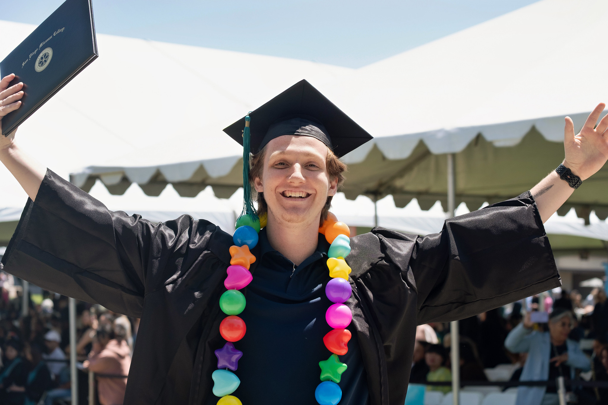 
A graduate holds up his degree.
