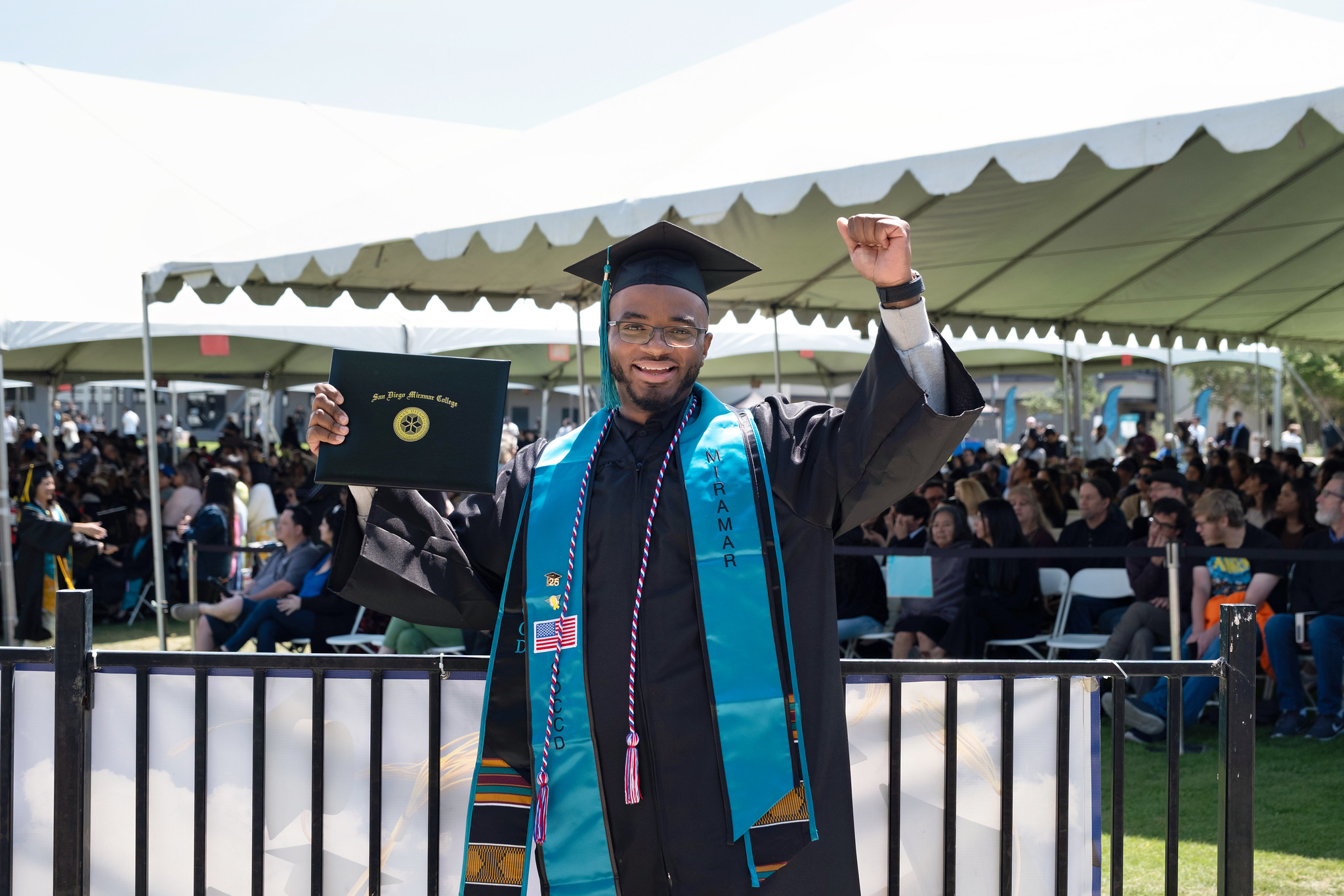 
A graduate holds up his degree.
