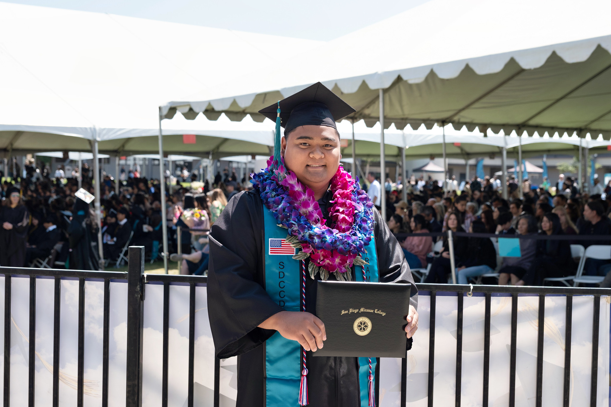 
A graduate holds up his degree.
