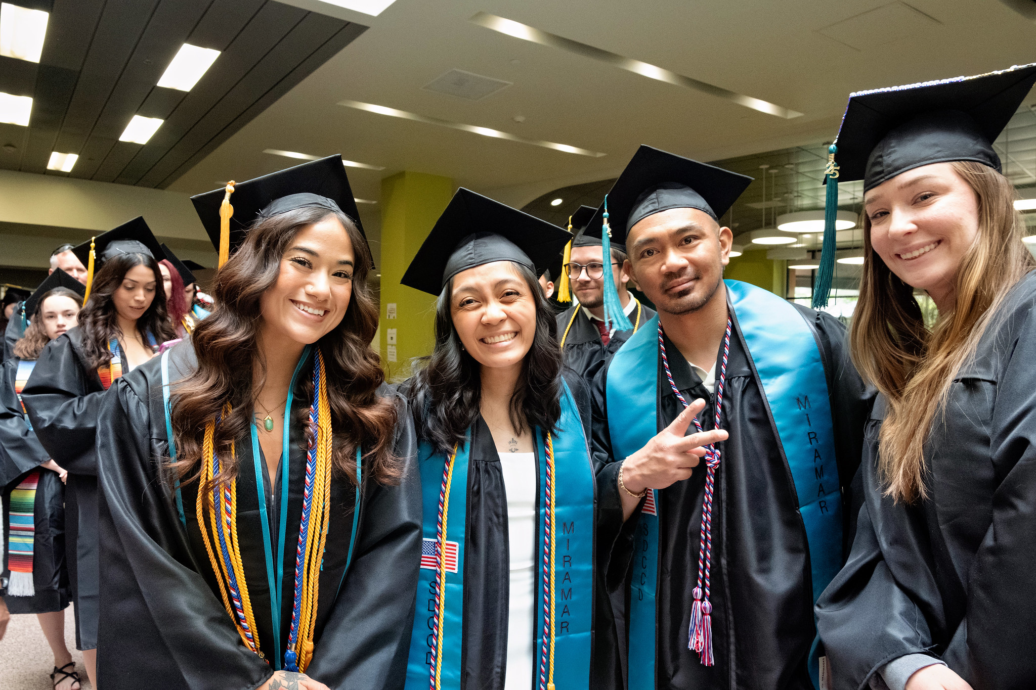 
Four graduates waiting to walk out to commencement.
