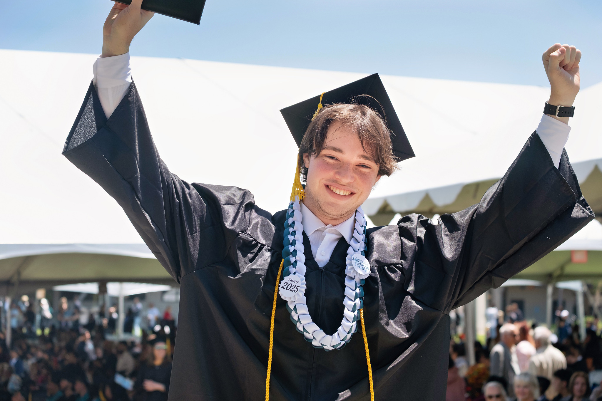 
A graduate holds up his degree.
