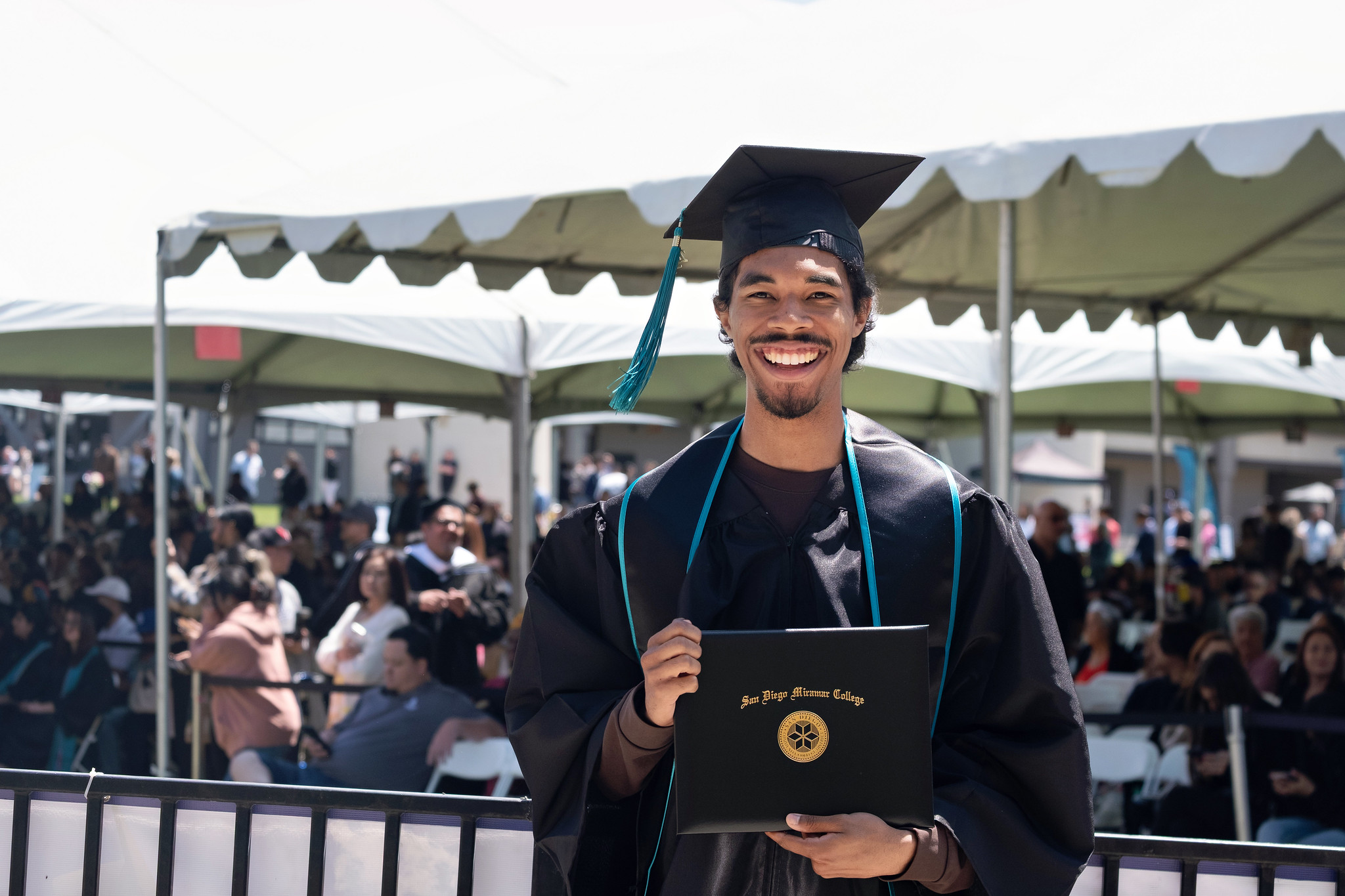 
A graduate holds up his degree.
