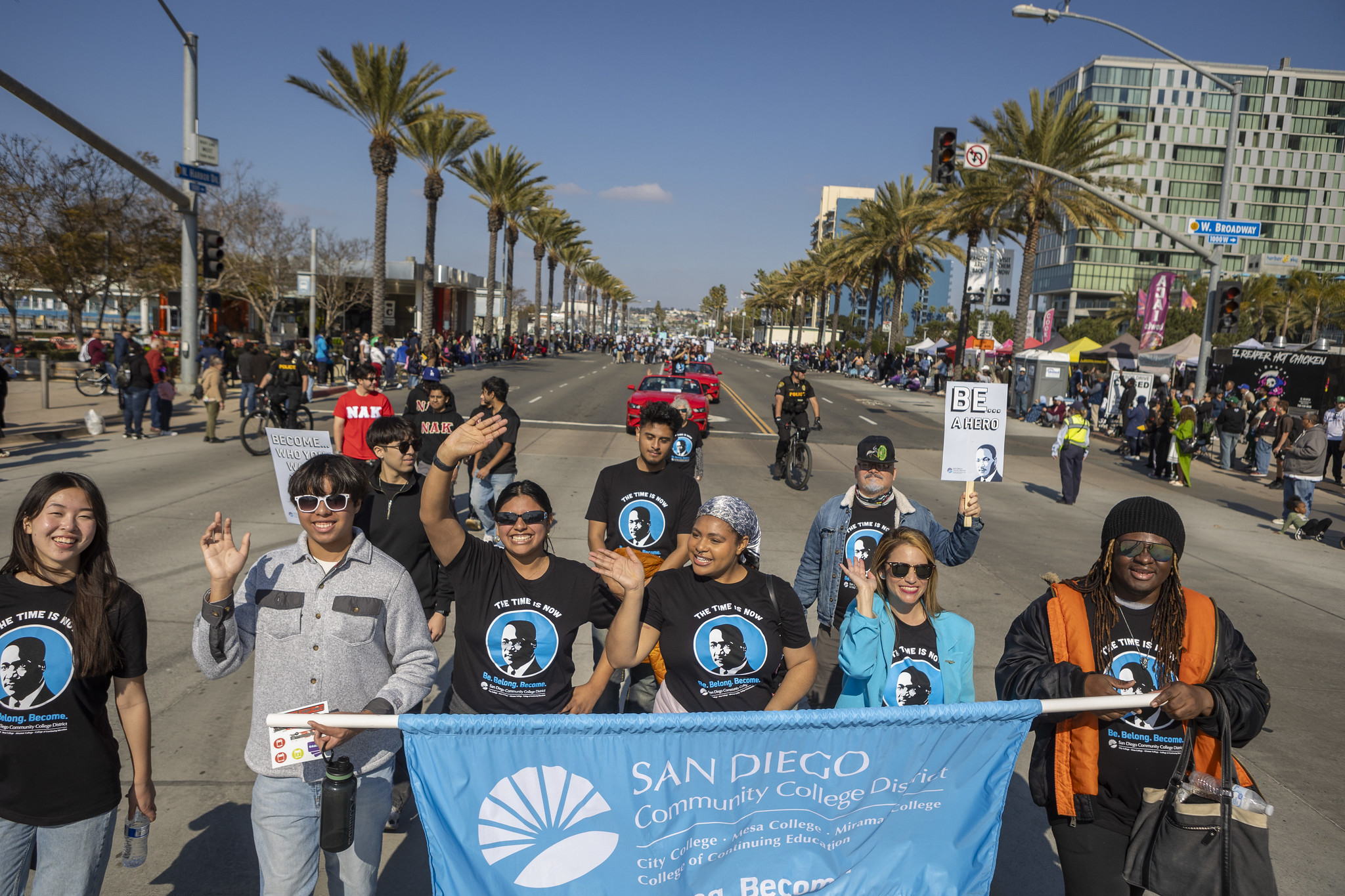 Student leaders hold a blue district banner as the walk in the parade.
