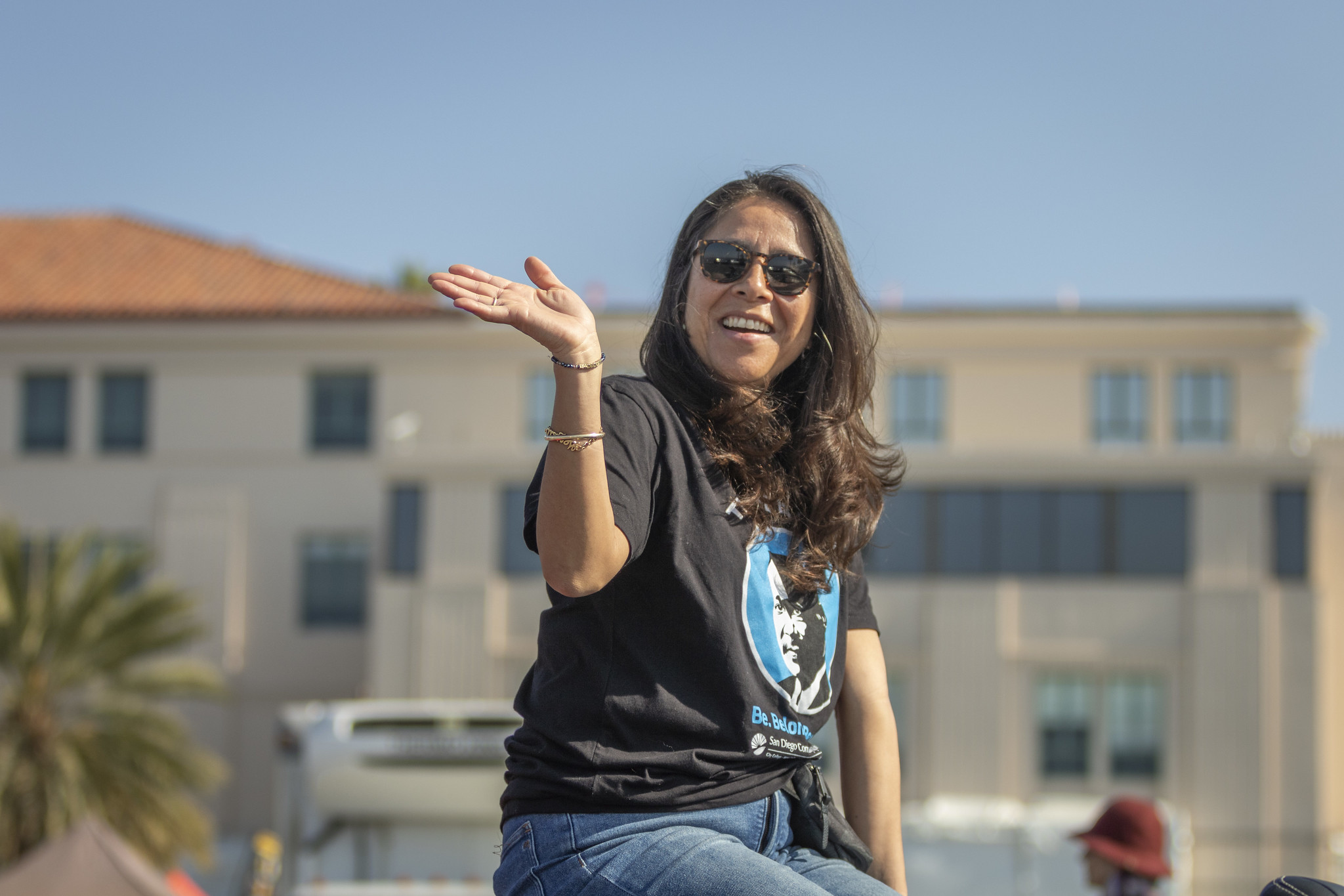 Trustee Geysil Arroyo rides in a convertible car.