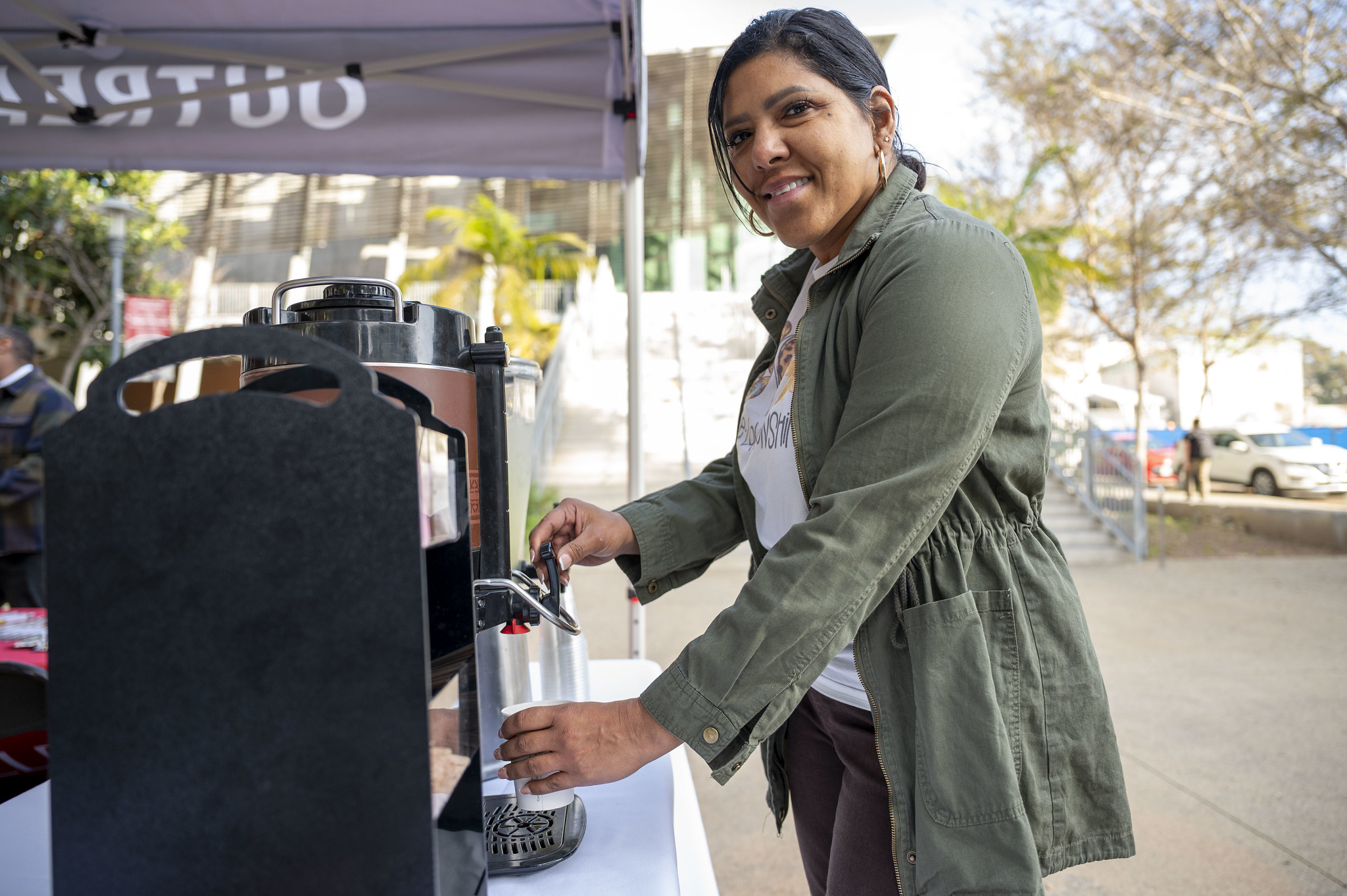 
A lady gets coffee at a welcome booth.
